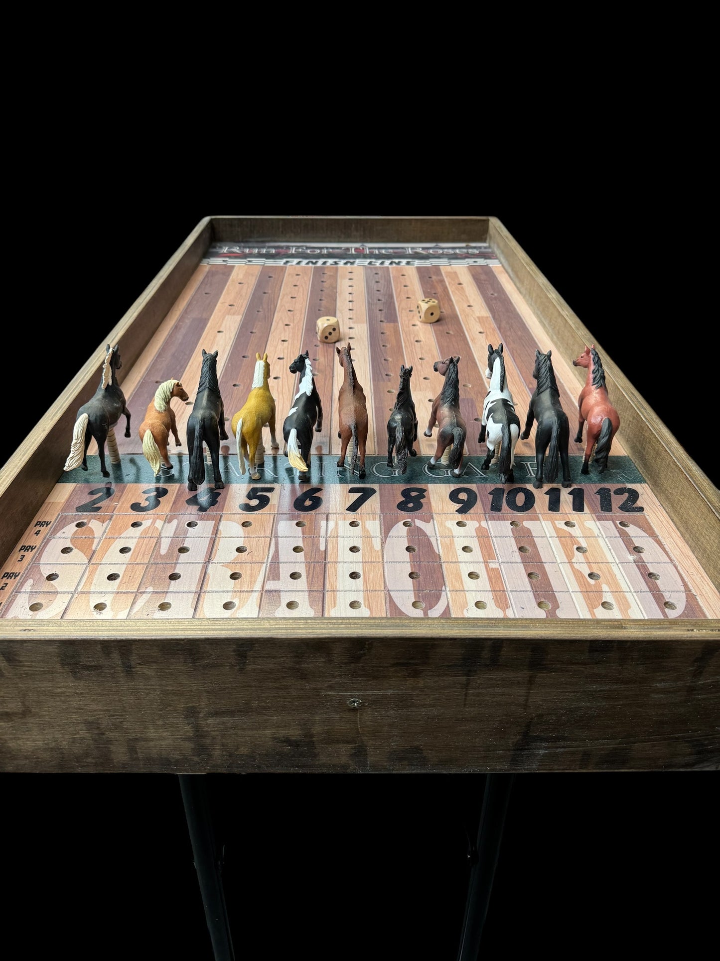 a group of toy horses on top of a wooden table