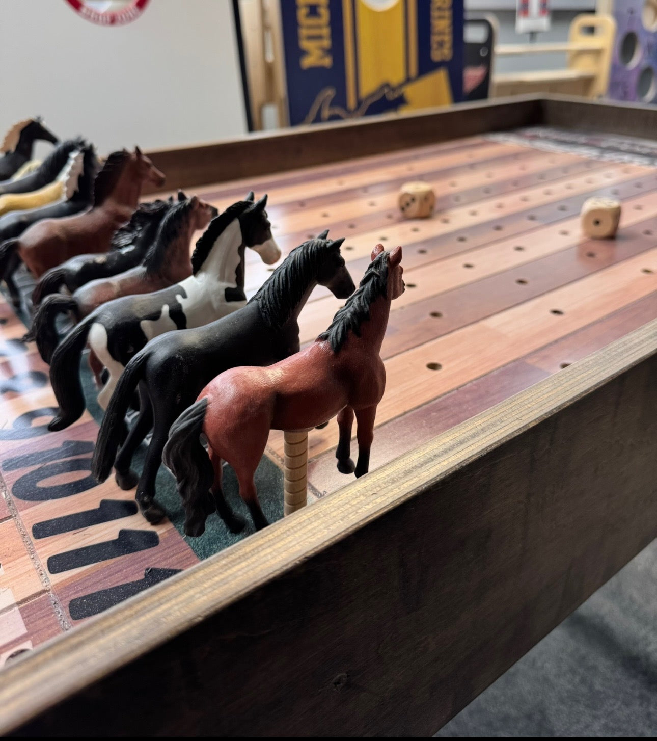 a group of toy horses sitting on top of a wooden table